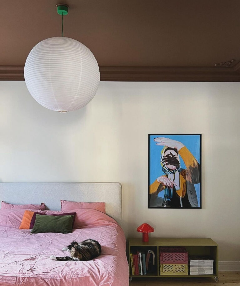 Scandinavian bedroom with a dark brown ceiling making the room feel cozy.