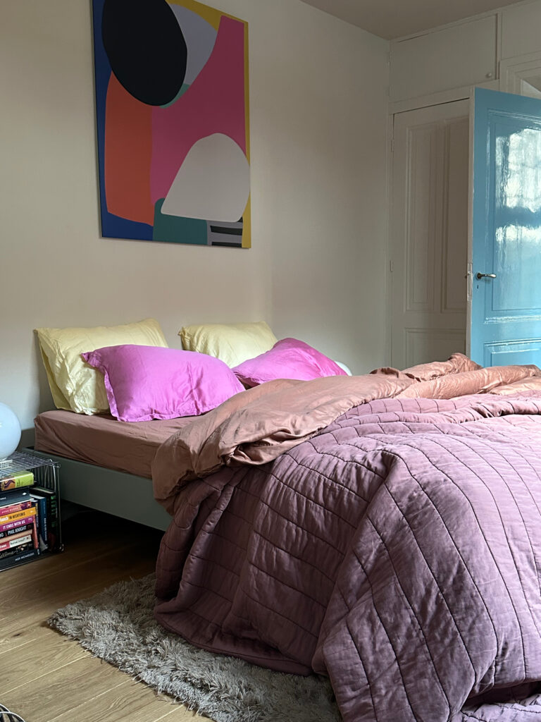 Colorful bedroom with a large art print and pink and yellow bedding