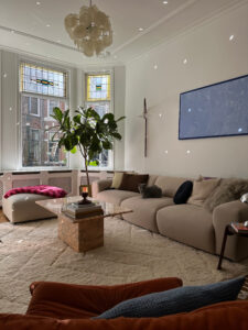 Colorful details in a bright and airy licingroom with beige sofa and light refelctions.