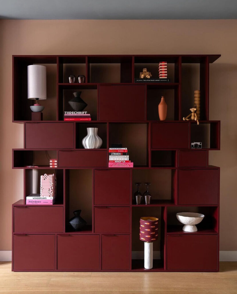 Deep dark red bookshelf from Tylko in a colorful home.