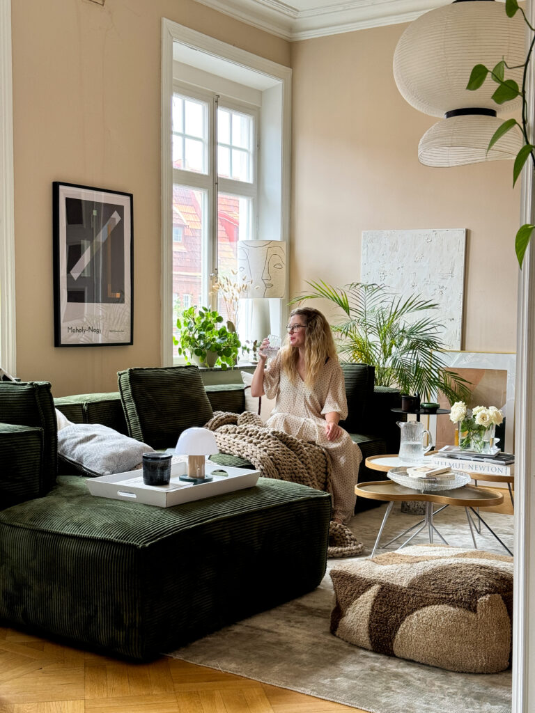 Large manchester sofa in a forest dark green color in a Scandinavian apartment