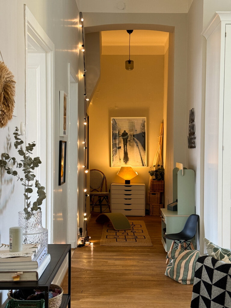 Long hallway styled with a centerpiece and details along the walls to make the Scandinavian home feel homely