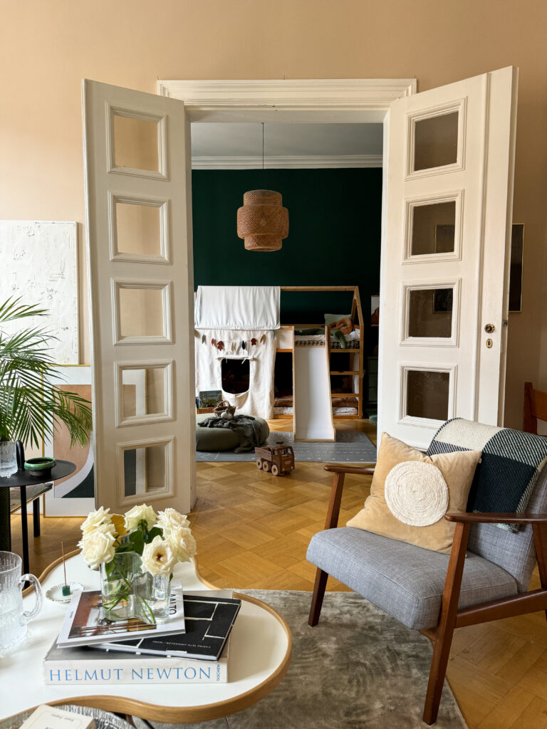 Double doors in to a kids room in dark green in a Scandinavian apartment in Sweden.