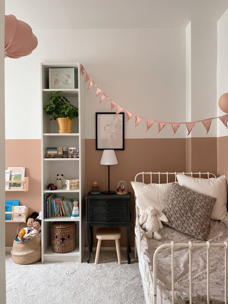 Scandinavian kids room painted in the color Blushing Peach from Jotun and furnished with rug, shelf and bed from IKEA.