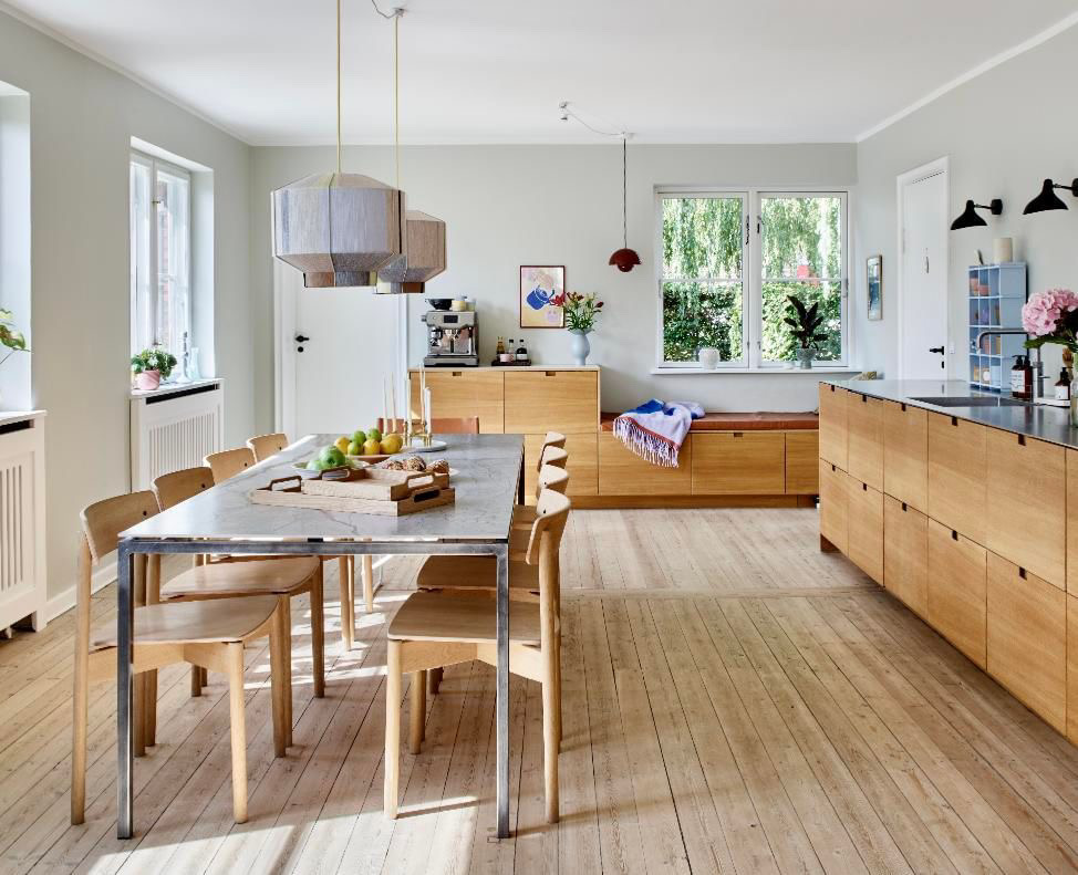 Kitchen sofa by the window in a Danish kitchen with natural wood and colorful details.