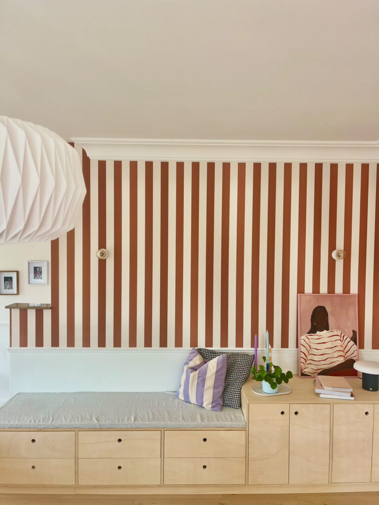 Seating area, banquette in a colorful home with striped walls and playful details.