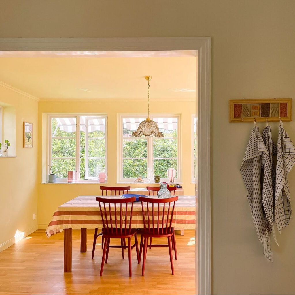 View into a bright yellow and colorful dining room where the walls and ceiling are painted in the same color.