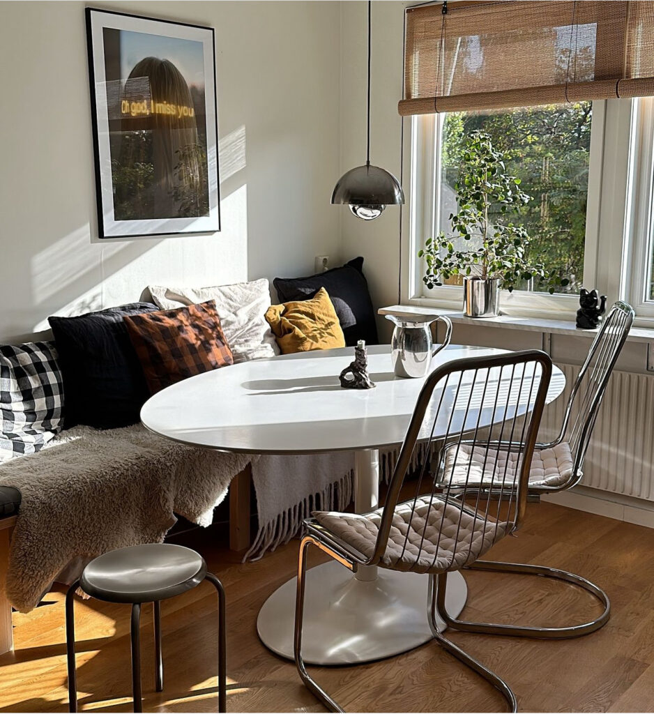 Kitchen sofa in a Scandinavian home with italian chairs and neutral earthy colors on the textiles.