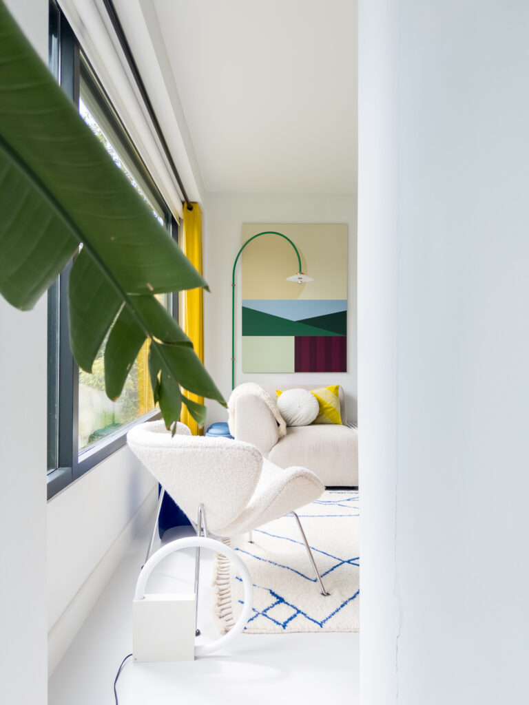 View into living room with white furniture and designer furniture, minimalistic and Scandinavian styled.